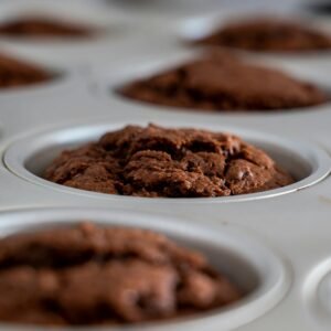About Snackit Close-up of freshly baked chocolate muffins cooling in a muffin pan. Perfect dessert or snack.